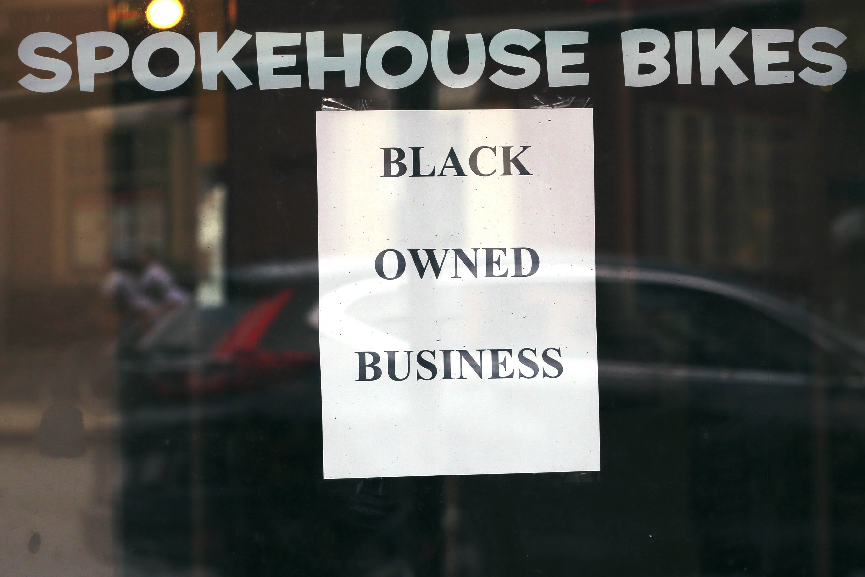 A sign in the window informs passersby that Spokehouse Bikes in the Upham's Corner neighborhood of Boston is a Black-owned business. | AP Photo/Charles Krupa