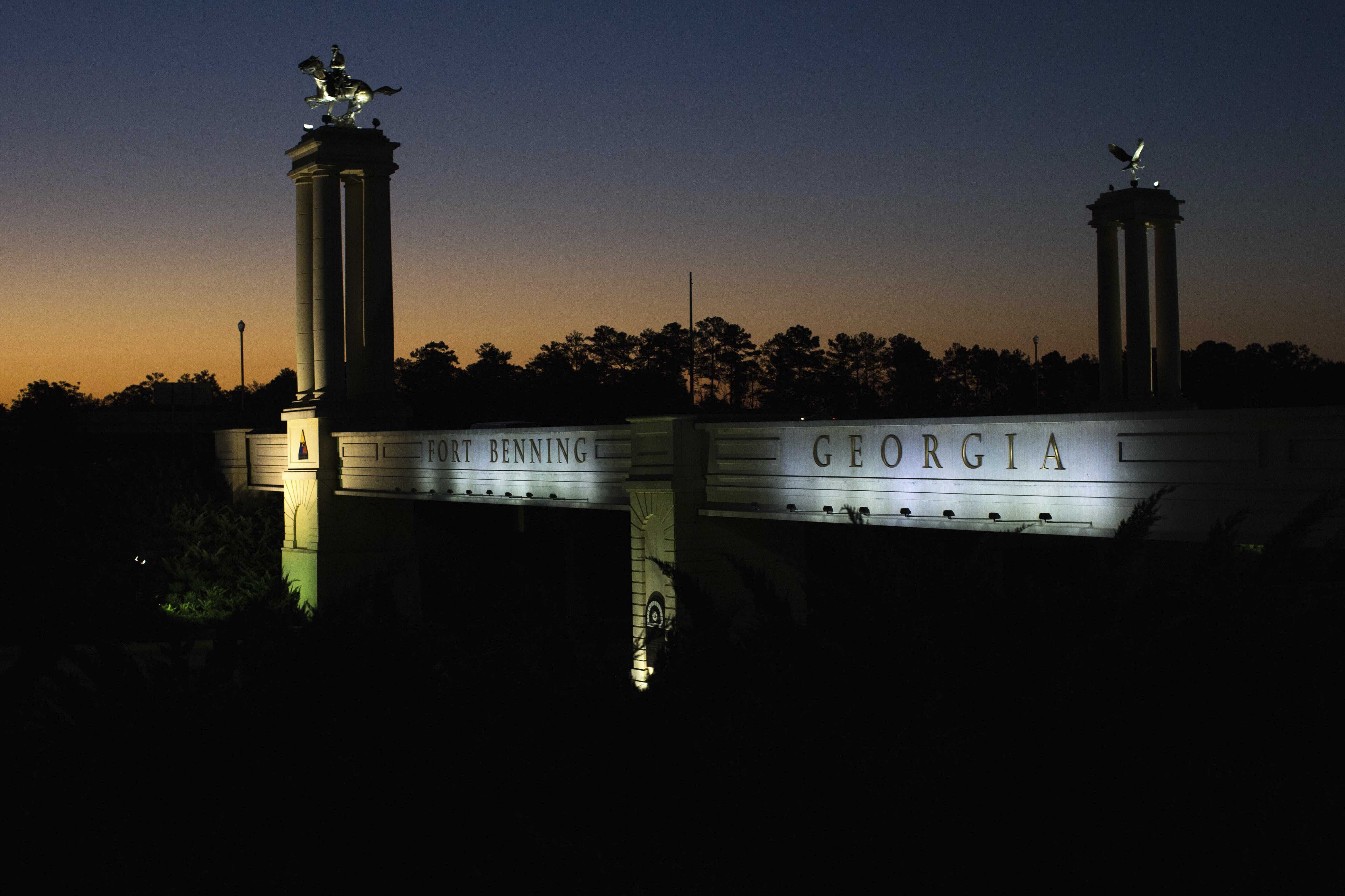 A bridge marks the entrance to the U.S. Army's Fort Benning as the sun rises in Columbus, Ga. Fort Benning is named after Confederate officers.