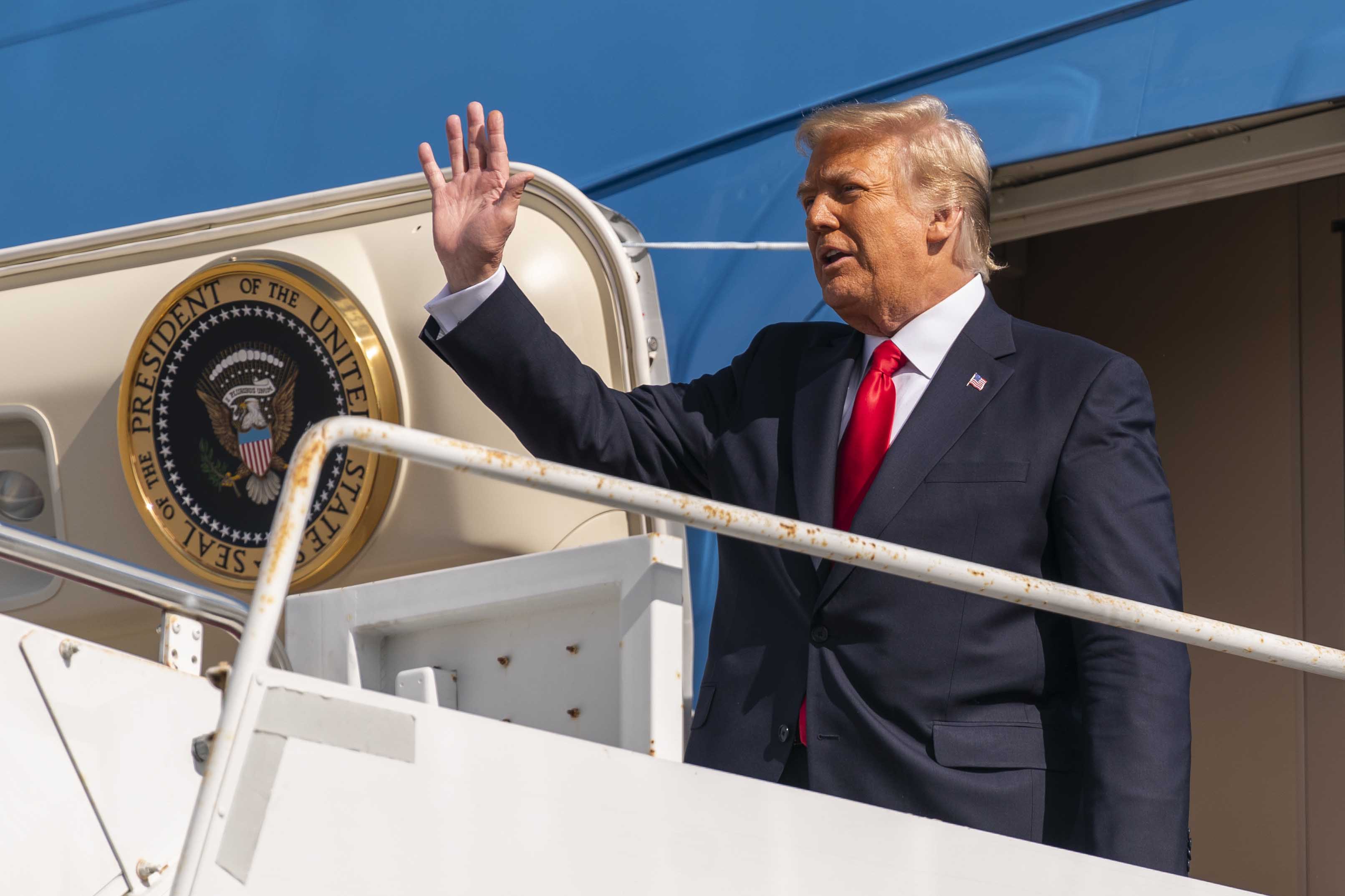 Former President Donald Trump waves as he disembarks from his final flight on Air Force One at Palm Beach International Airport in West Palm Beach, Fla., Wednesday, Jan. 20, 2021.