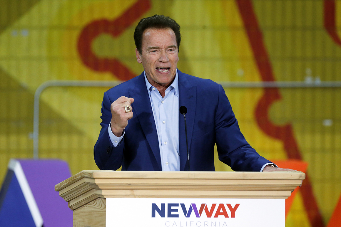 Arnold Schwarzenegger speaks on stage at a 2018 political event.