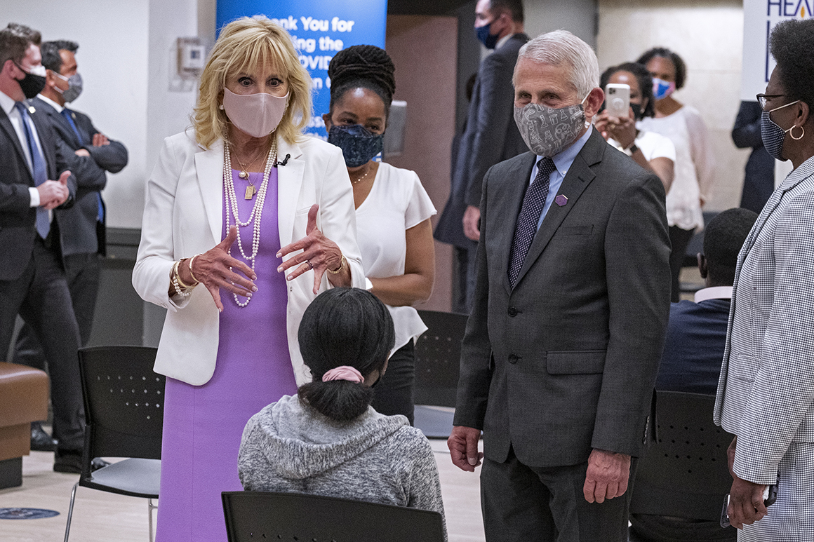 First lady Jill Biden and Anthony Fauci speak to a person at a vaccine clinic.
