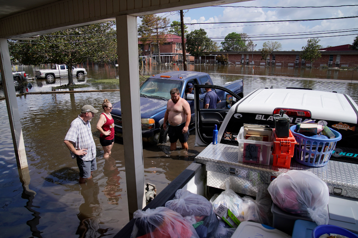 People stand in floodwaters in the aftermath of Hurricane Ida.