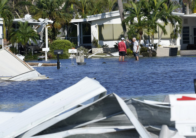 Trailer park residents talk in a flooded area after Hurricane Ian passed by.