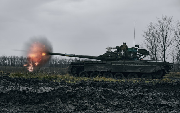 Ukrainian army fires a captured Russian tank T-80 in a field with mud.