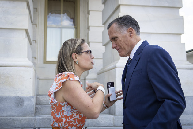 Sen. Kyrsten Sinema (I-Ariz.) talks with Sen. Mitt Romney (R-Utah) outside the U.S. Capitol.