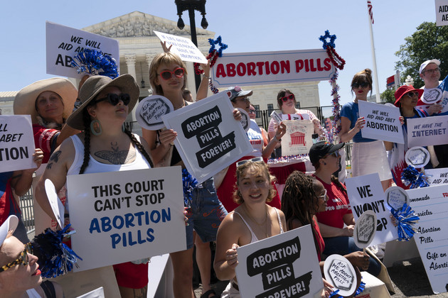Abortion rights activists setup an abortion pills educational booth as they protest outside the Supreme Court.
