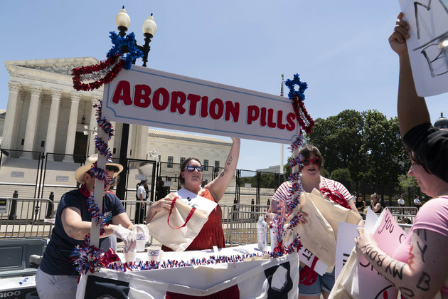 Abortion-rights activists setup an abortion pills educational booth as they protest outside the Supreme Court.