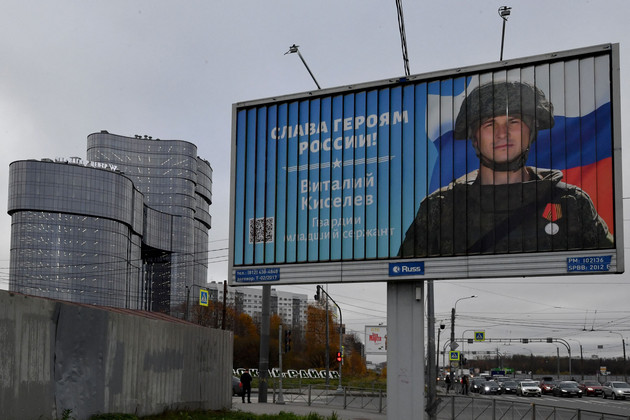 A poster displaying a Russian soldier with a slogan reading Glory to the Heroes of Russia decorates a street near the PMC Wagner Centre.