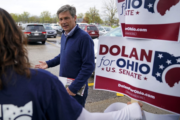 Matt Dolan, center, visits with a campaign worker outside a polling place.