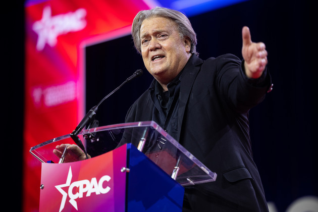 Former Trump advisor Steve Bannon gesturing while speaking at a CPAC-branded podium.