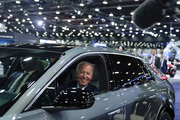 President Joe Biden drives a Cadillac Lyriq through the showroom during a tour at the Detroit Auto Show