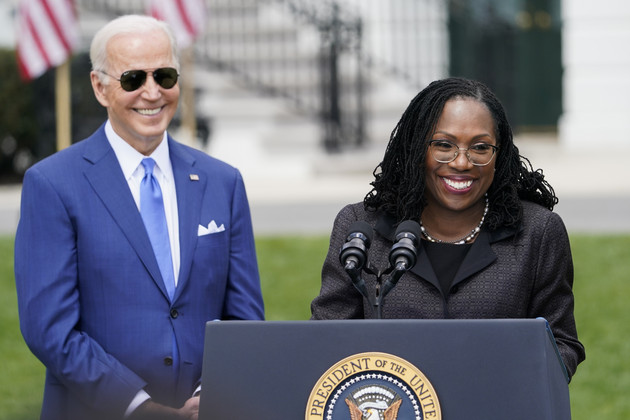 Joe Biden stands next to Ketanji Brown Jackson speaking at a White House lectern on the South Lawn.