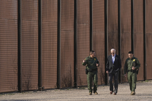 President Joe Biden walks with U.S. Border Patrol agents along a stretch of the U.S.-Mexico border.