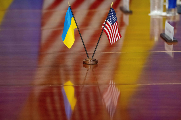 The Ukrainian and United States flags are placed on the table during a meeting.