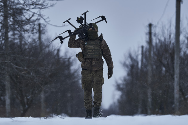 A Ukrainian soldier carries a drone close to the frontline.