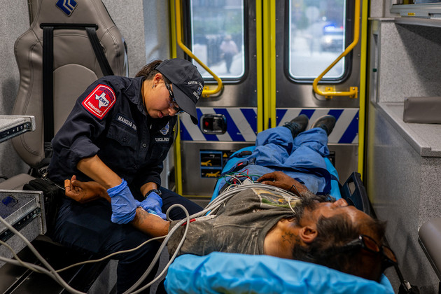  A Travis County medic assists a patient in an ambulance.