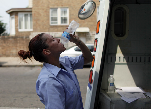 U.S. Postal Service letter carrier Monique Miller drinks from a bottle of water.