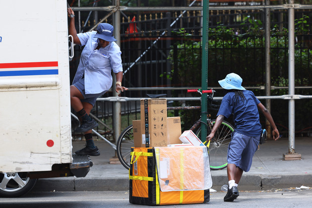 Mail delivery workers unload a truck in Brooklyn during a heat wave. 