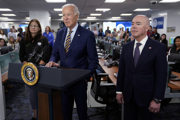 President Joe Biden speaks during a visit to FEMA headquarters in Washington. Homeland Security Secretary Alejandro Mayorkas (right) and FEMA Associate Administrator of the Office of Response and Recovery Anne Bink (left) listen.